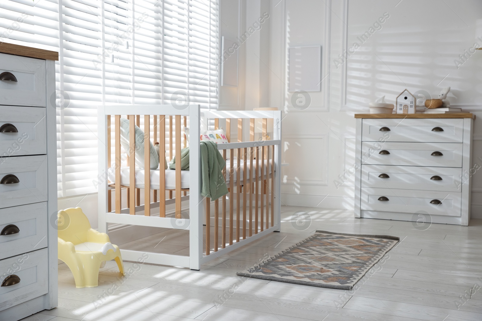 Stylish baby's room with crib and chest of drawers. Interior design Photo of Stylish baby's room with crib and chest of drawers. Interior design