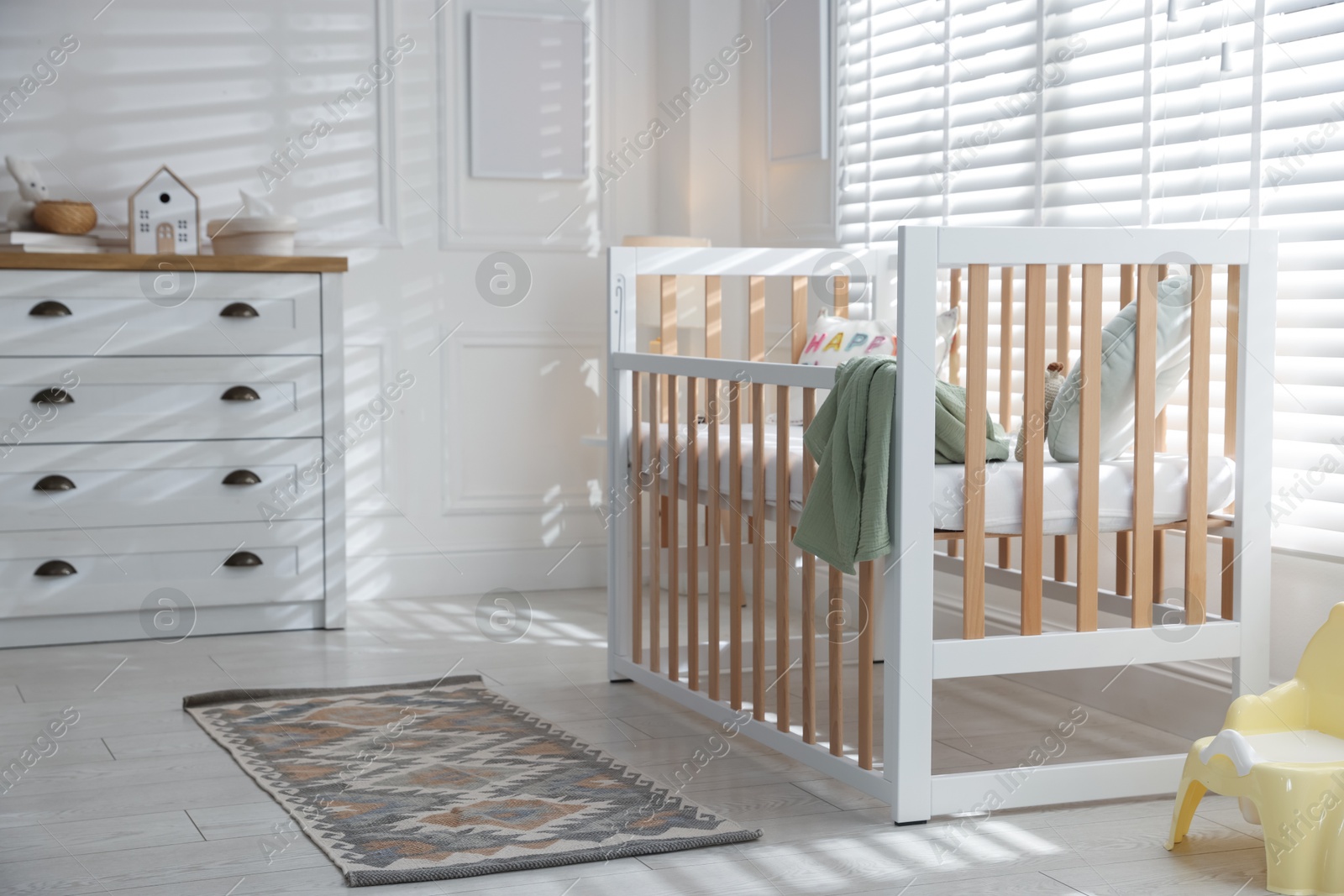 Stylish baby's room with crib and chest of drawers. Interior design Photo of Stylish baby's room with crib and chest of drawers. Interior design