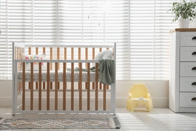 Photo of Stylish baby's room with crib. Interior design