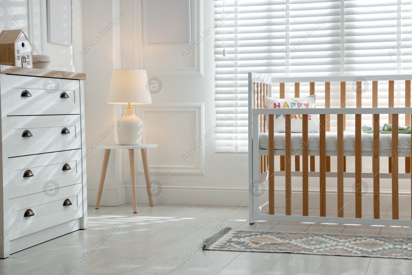 Stylish baby's room with crib and chest of drawers. Interior design Photo of Stylish baby's room with crib and chest of drawers. Interior design