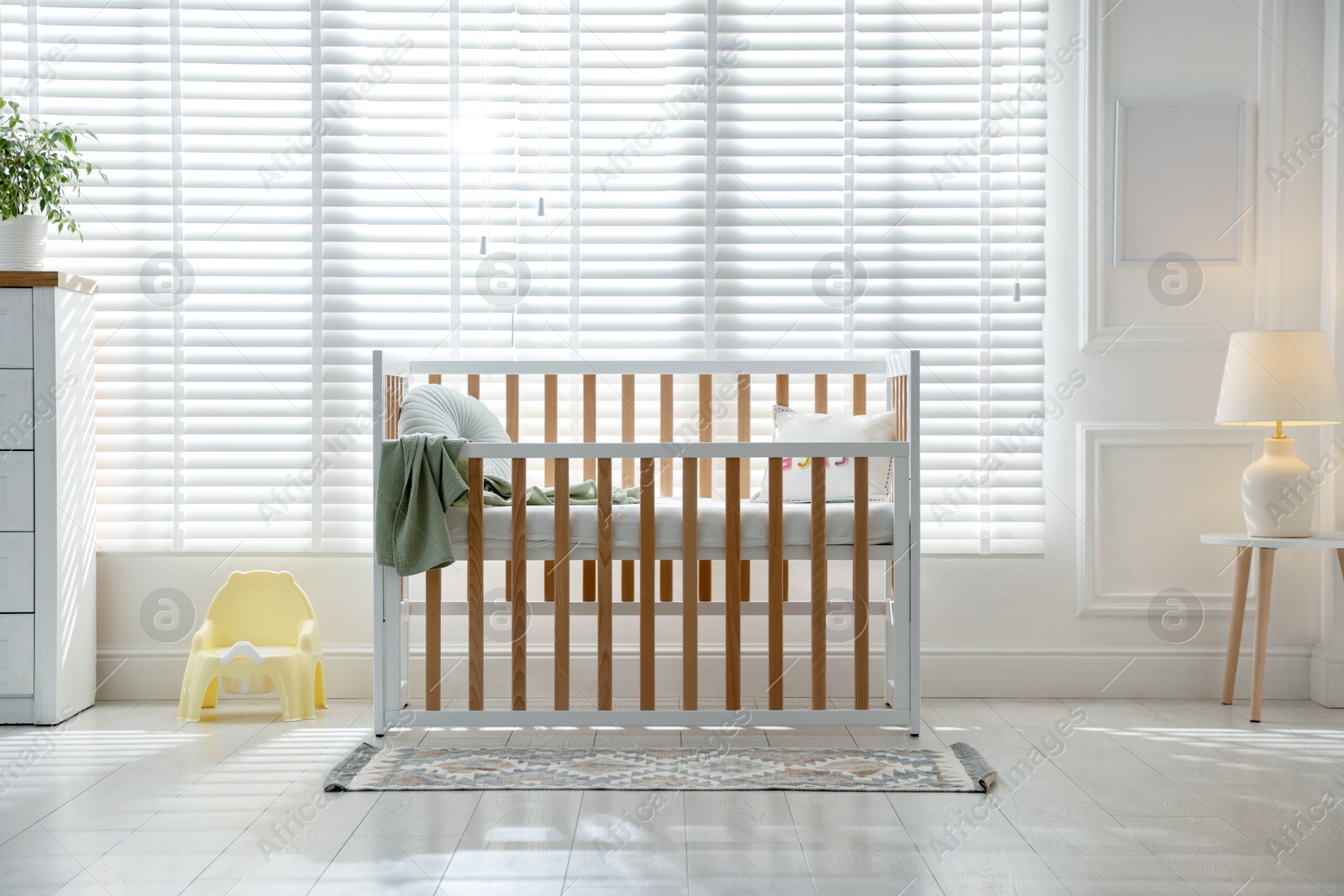 Photo of Stylish baby's room with crib. Interior design
