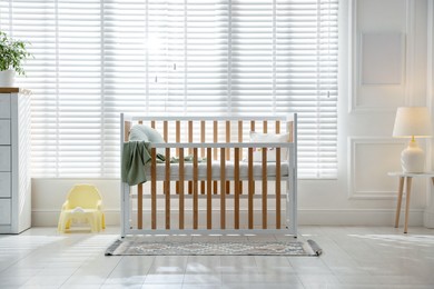 Photo of Stylish baby's room with crib. Interior design