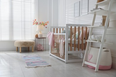 Photo of Stylish baby's room with crib. Interior design
