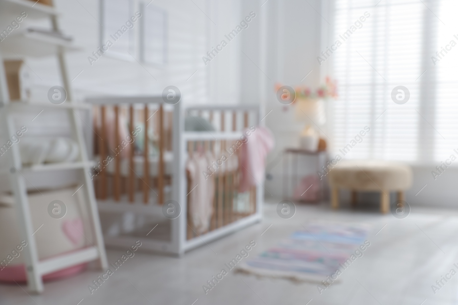 Photo of Blurred view of baby's room with stylish crib
