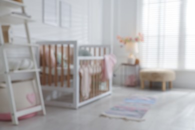 Photo of Blurred view of baby's room with stylish crib