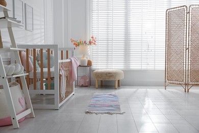 Photo of Stylish baby's room with crib. Interior design