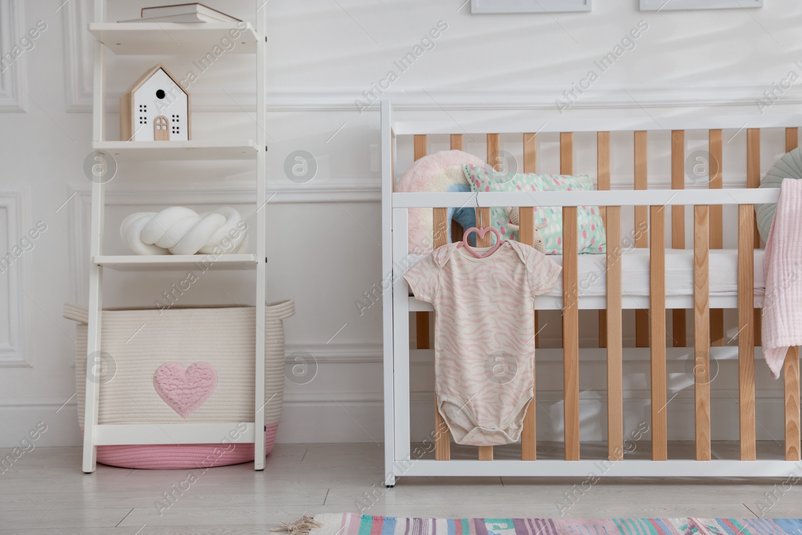 Photo of Crib with onesie and shelving unit in baby's room