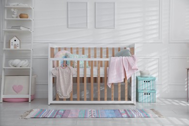 Photo of Stylish baby's room with crib and shelving unit. Interior design