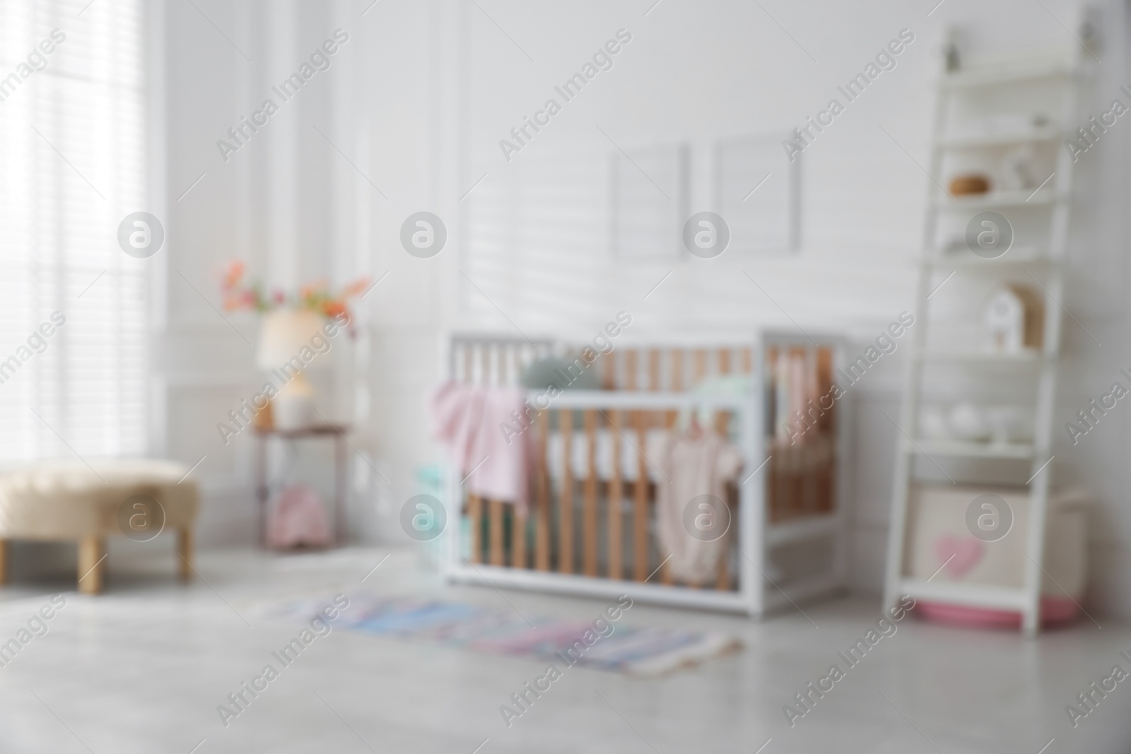 Photo of Blurred view of baby's room with stylish crib