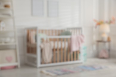 Photo of Blurred view of baby's room with stylish crib