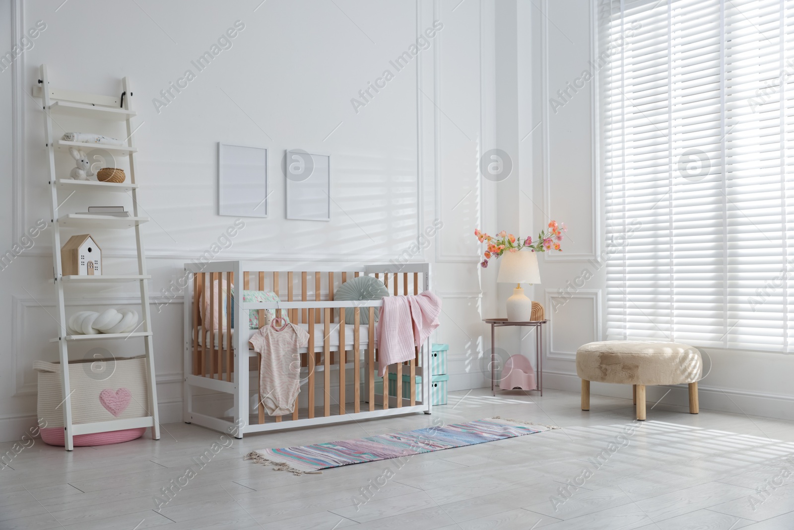 Photo of Stylish baby's room with crib and shelving unit. Interior design