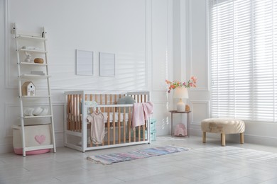 Photo of Stylish baby's room with crib and shelving unit. Interior design