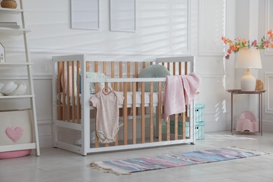 Photo of Stylish baby's room with crib and shelving unit. Interior design