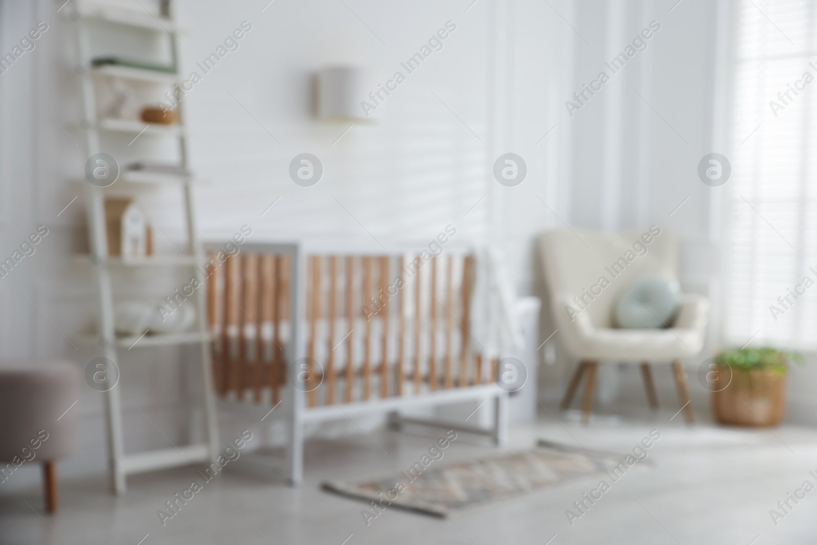 Photo of Blurred view of baby's room with stylish crib