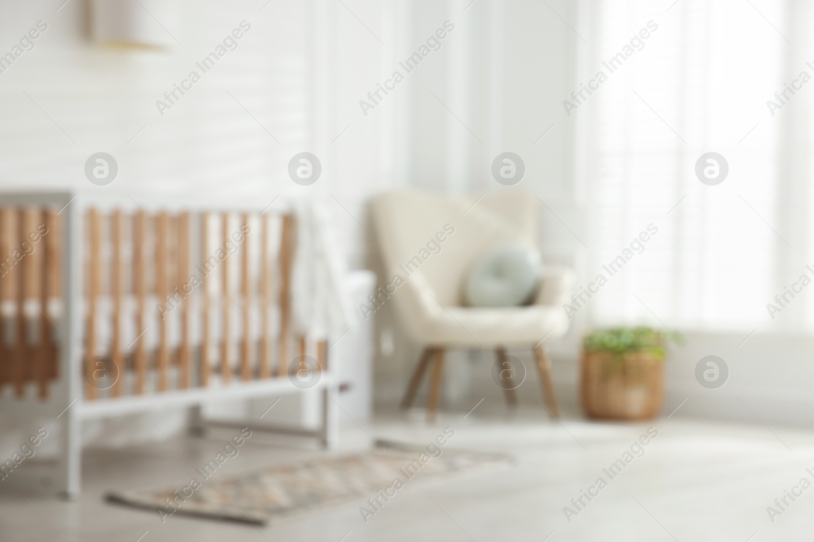 Photo of Blurred view of baby's room with stylish crib