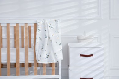 Photo of Stylish baby's room with crib and drawers, closeup. Interior design