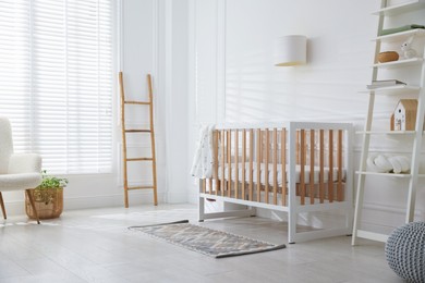 Photo of Stylish baby's room with crib and shelving unit. Interior design