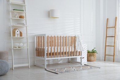 Photo of Stylish baby's room with crib and shelving unit. Interior design