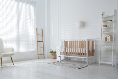 Photo of Stylish baby's room with crib and shelving unit. Interior design