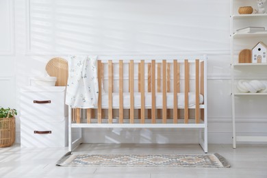 Photo of Stylish baby's room with crib and shelving unit. Interior design