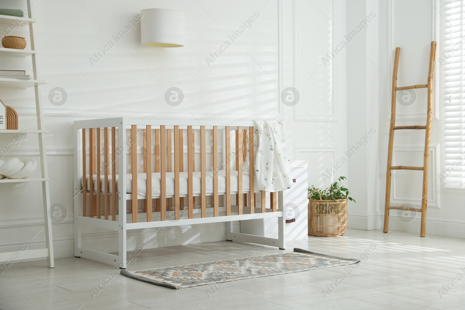 Photo of Stylish baby's room with crib. Interior design