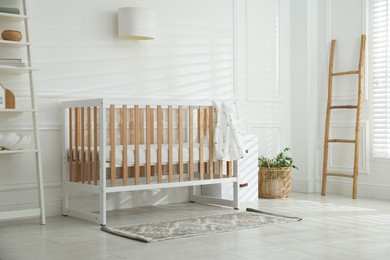 Photo of Stylish baby's room with crib. Interior design