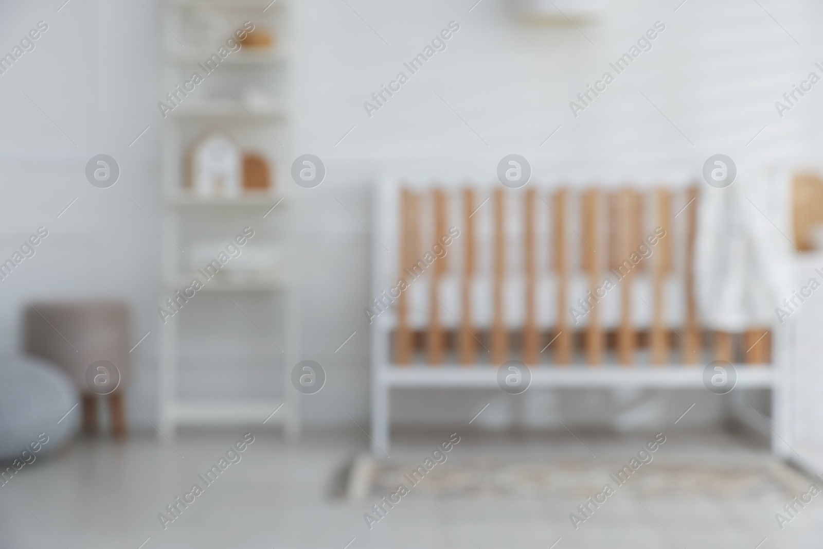 Photo of Blurred view of baby's room with stylish crib