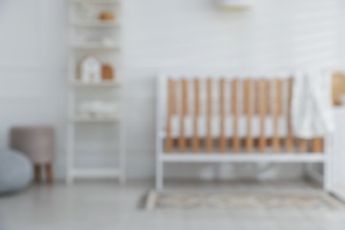Photo of Blurred view of baby's room with stylish crib