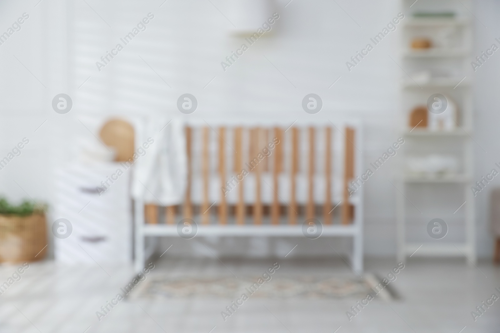 Photo of Blurred view of baby's room with stylish crib