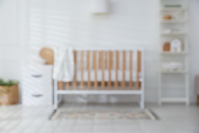 Photo of Blurred view of baby's room with stylish crib