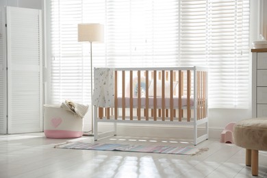 Photo of Stylish baby's room with crib. Interior design