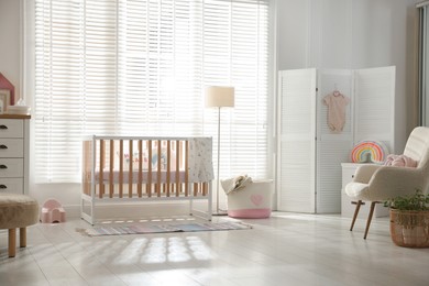Photo of Stylish baby's room with crib. Interior design