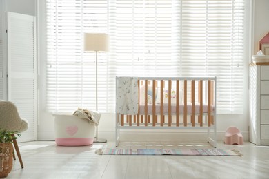 Photo of Stylish baby's room with crib. Interior design