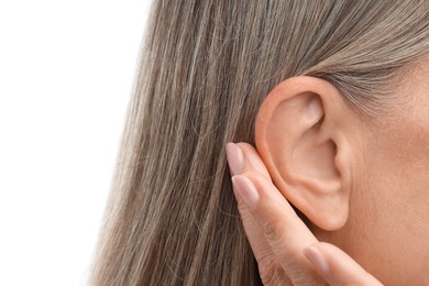 Photo of Sound. Senior woman showing hand to ear gesture on white background, closeup