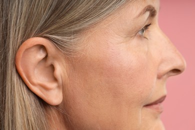 Photo of Sound. Senior woman on pink background, closeup