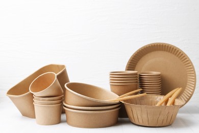 Photo of Set of disposable tableware on white table