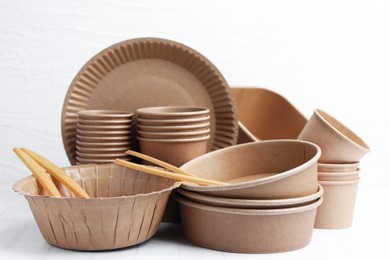 Photo of Set of disposable tableware on white table, closeup