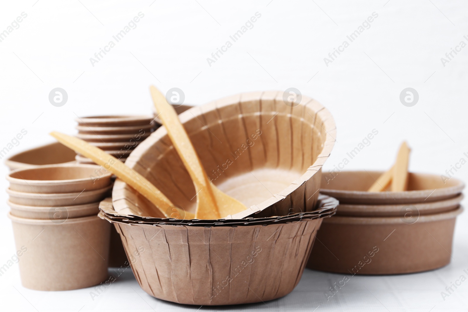 Photo of Set of disposable tableware on white table, closeup