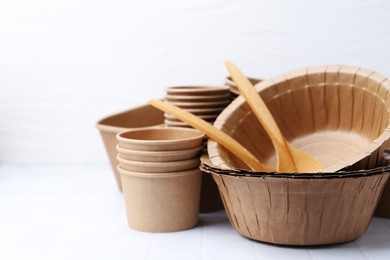 Photo of Set of disposable tableware on white table, closeup. Space for text