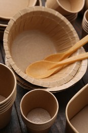 Photo of Set of disposable tableware on wooden table, closeup