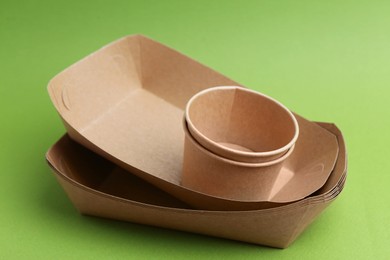 Photo of Set of disposable tableware on green background, closeup