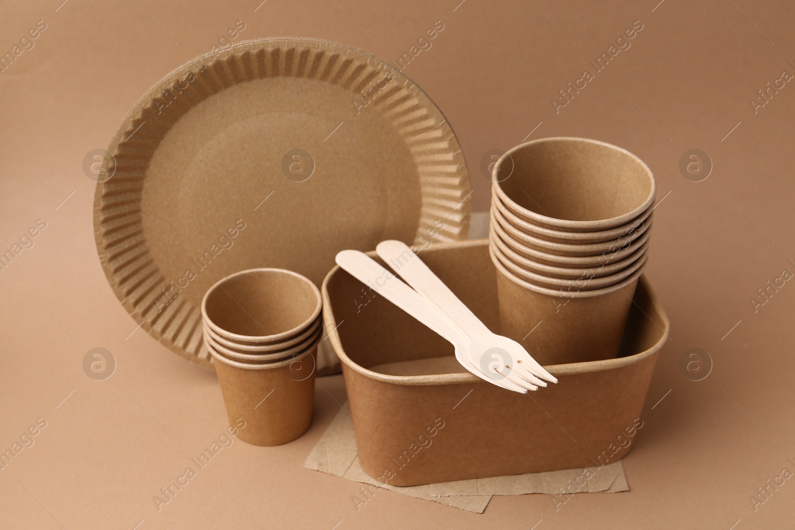 Set of disposable tableware on brown background, closeup Photo of Set of disposable tableware on brown background, closeup