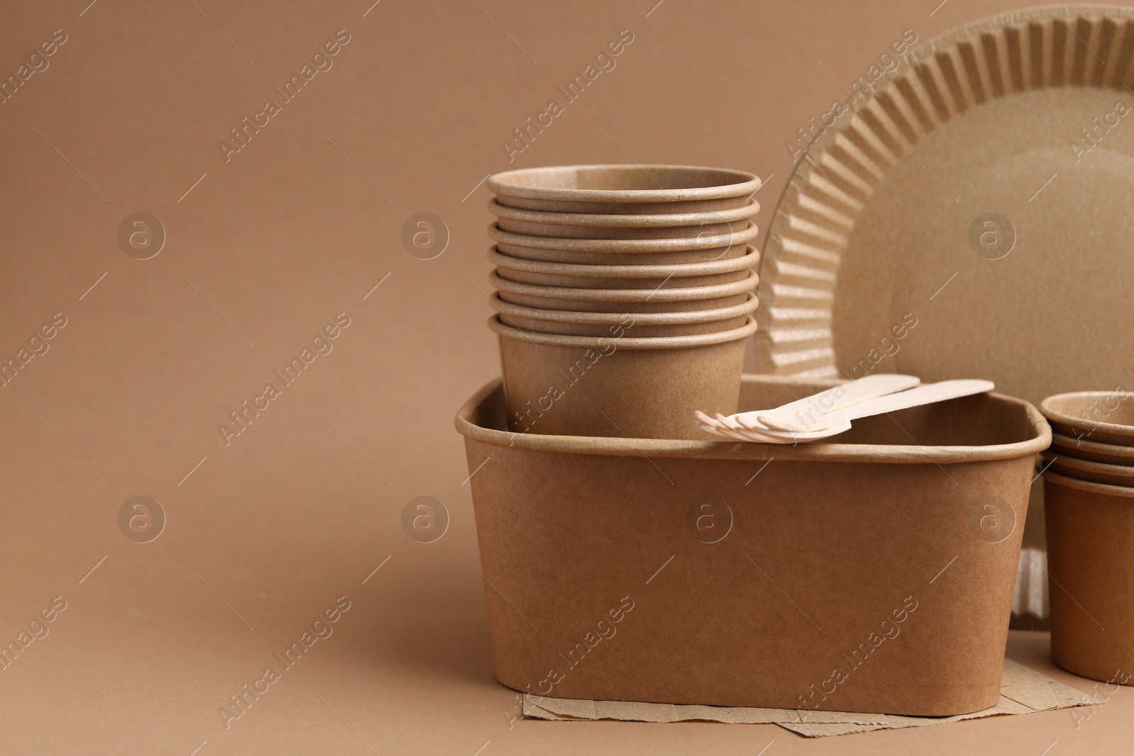 Set of disposable tableware on brown background, closeup. Space for text Photo of Set of disposable tableware on brown background, closeup. Space for text