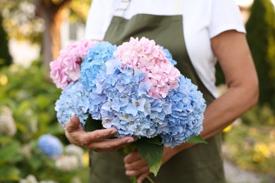 Photo of Senior woman with beautiful bouquet of flowers in garden, closeup