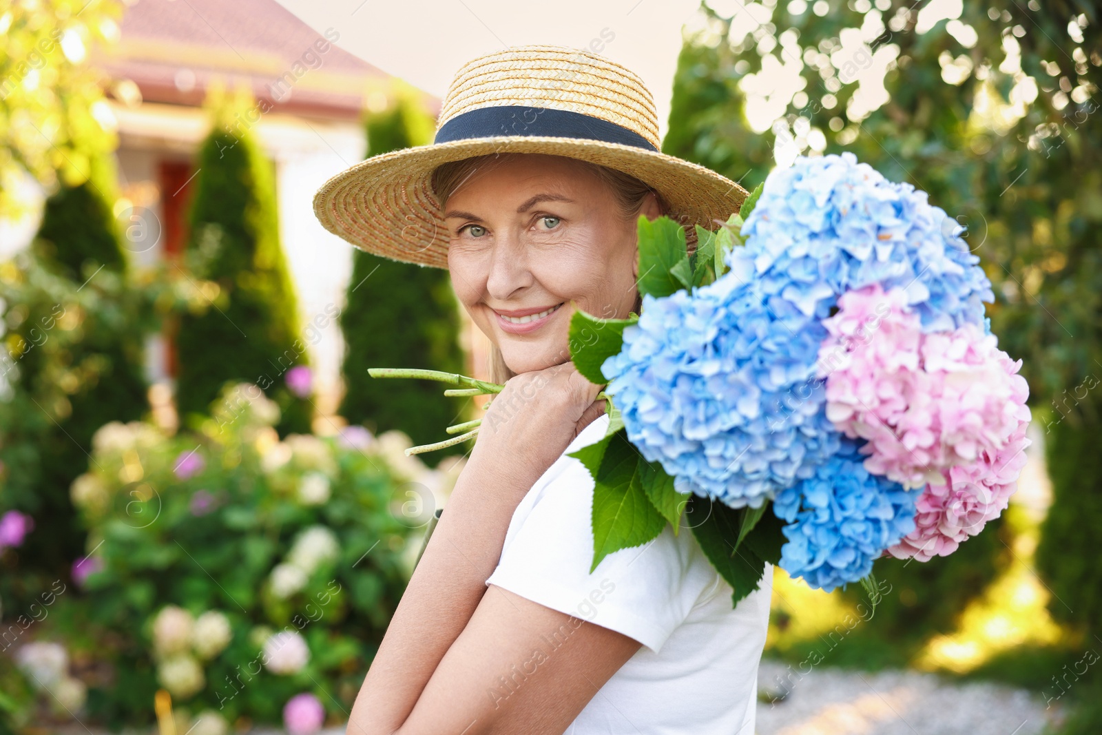 Senior woman with beautiful bouquet of flowers in garden Photo of Senior woman with beautiful bouquet of flowers in garden