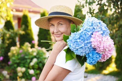 Photo of Senior woman with beautiful bouquet of flowers in garden