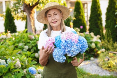 Photo of Senior woman with beautiful bouquet of flowers in garden