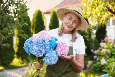 Photo of Senior woman with beautiful bouquet of flowers in garden
