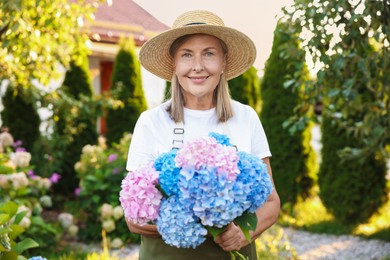 Photo of Senior woman with beautiful bouquet of flowers in garden