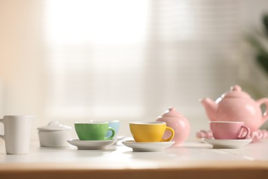 Photo of Tea set on white table indoors, closeup with space for text. Child's toy